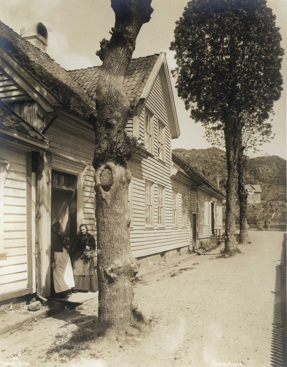 Gateparti, Flekkefjord, Vest-Agder. To kvinner i en døråpning. Fotografert 1912.