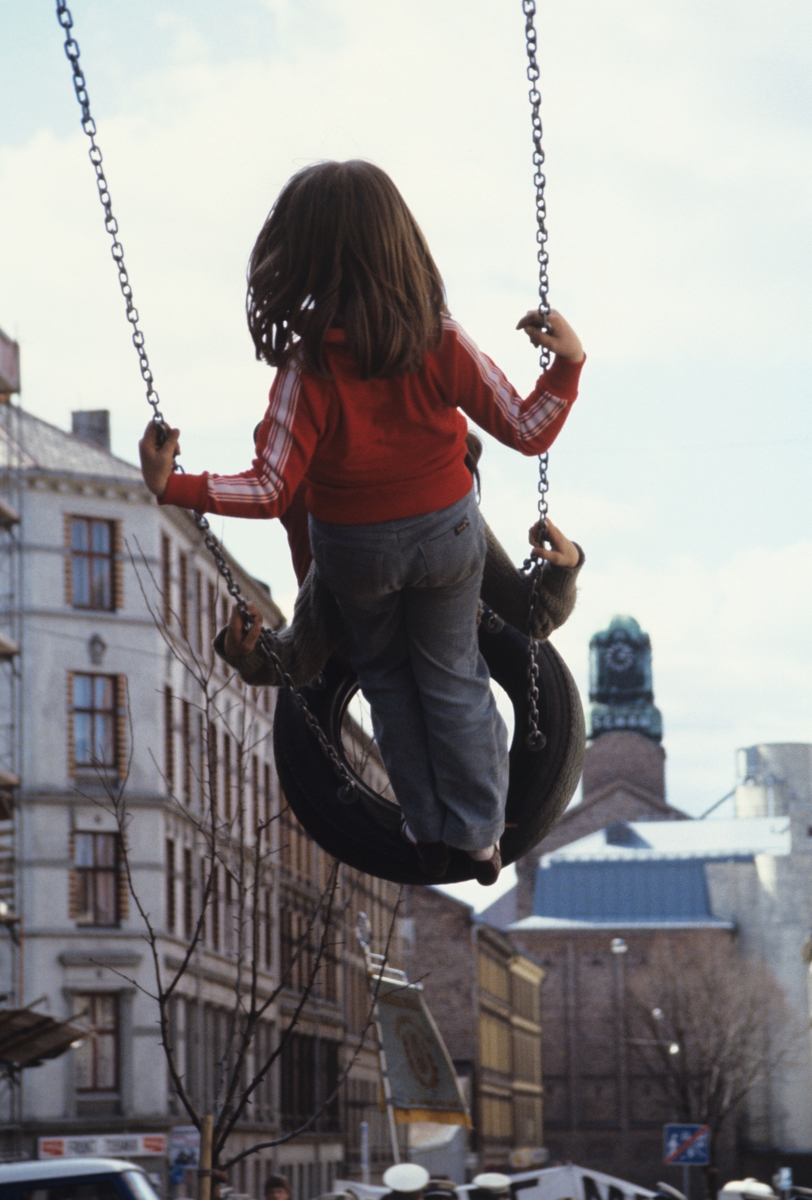 Barn på huske av bildekk. Bildet er antagelig tatt i forbindelse med en artikkel om byfornyelse på Grünerløkka i Oslo. Fotografert for Bonytt 1982.