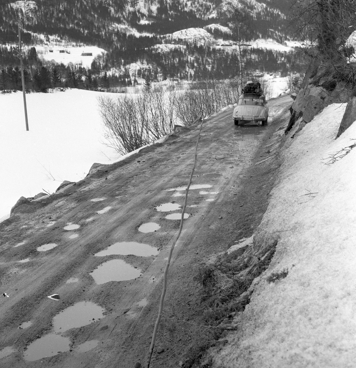 Hullete Riksvei 275 ved Kravik i Numedal. Fotografert påsken 1958.