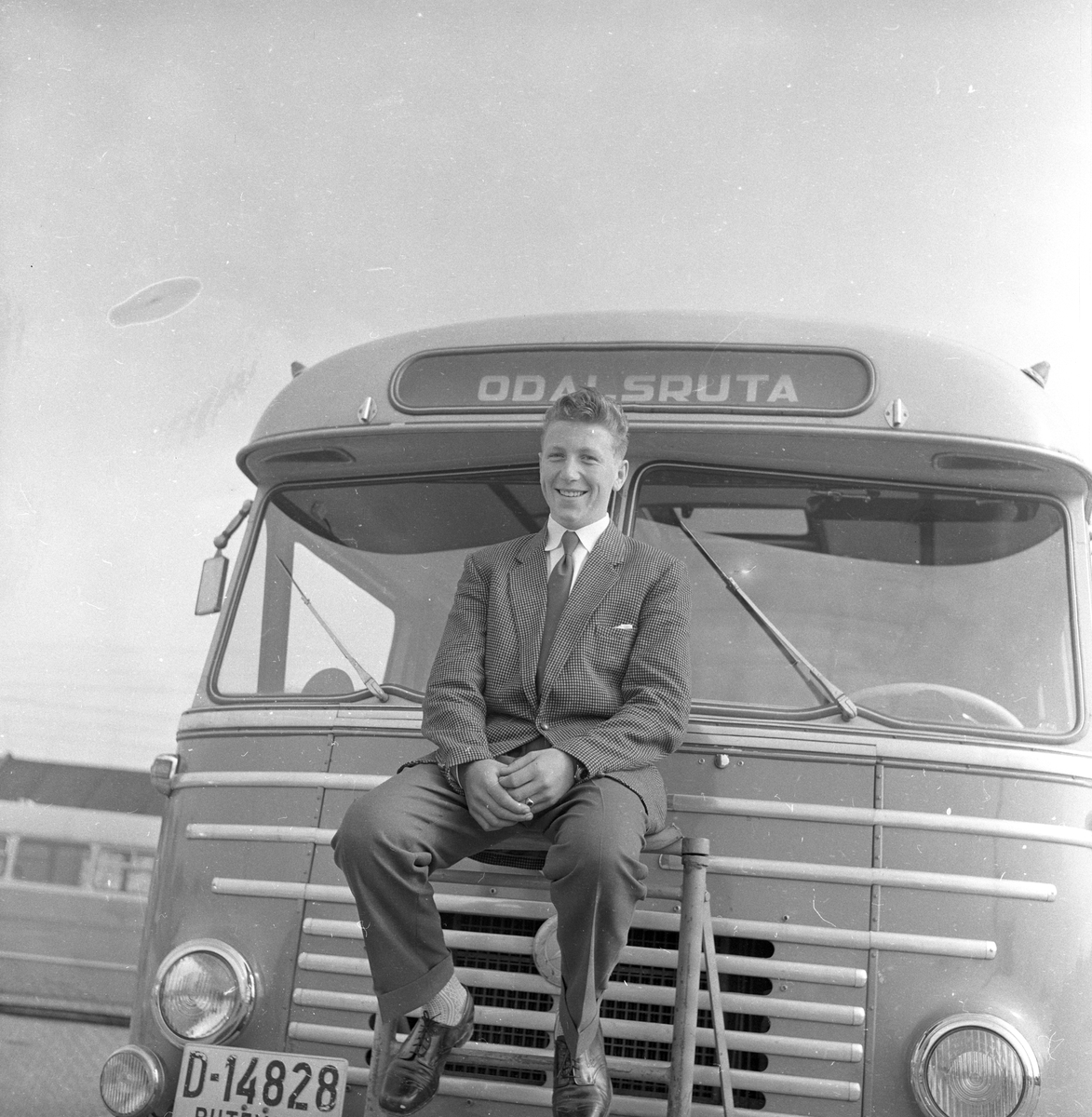 Mann sitter i fronten på bussen "Odalsruta".