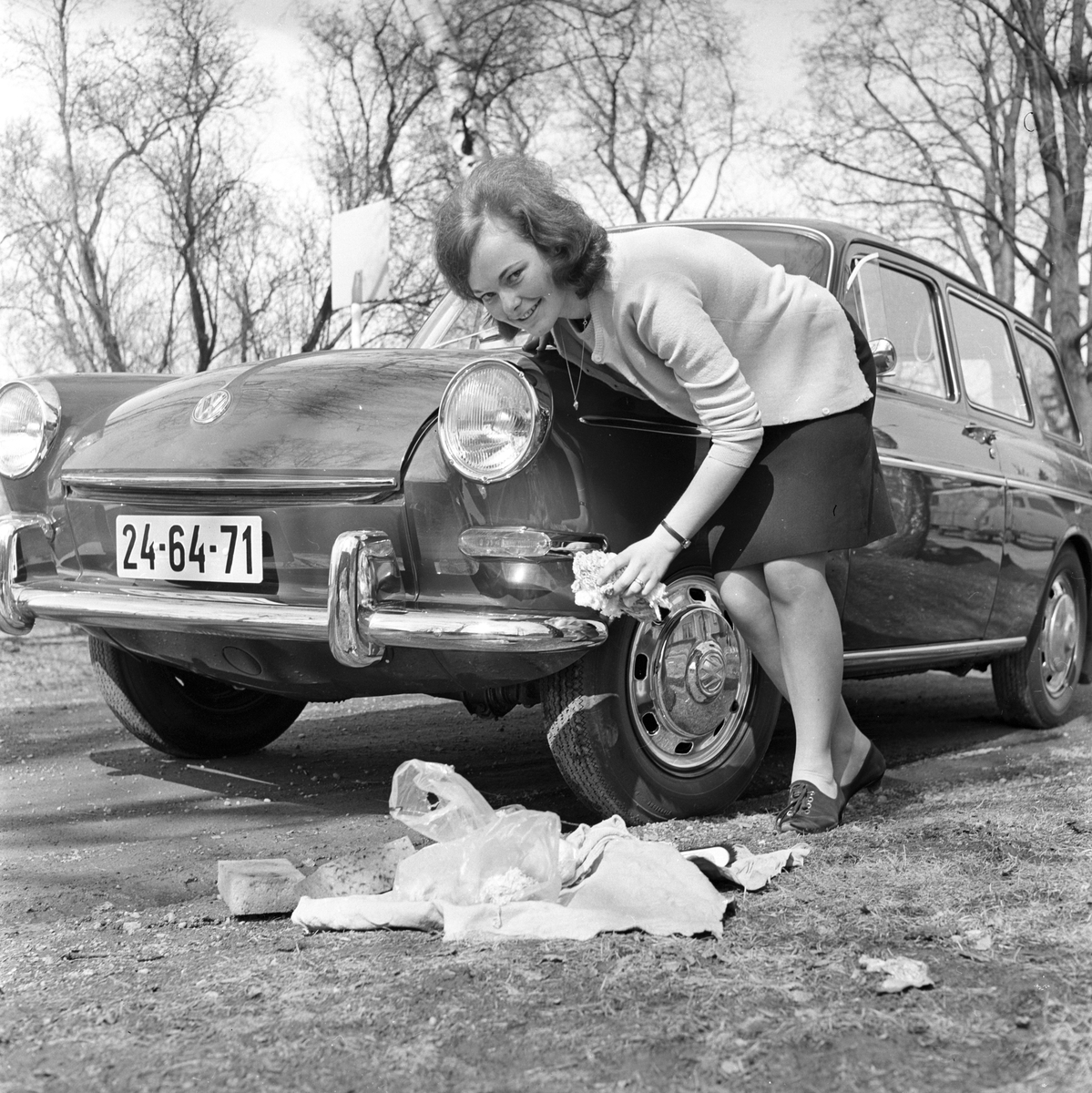 Vårpuss på bilen, dame vasker og steller bil. Fotografert 30. april 1966.