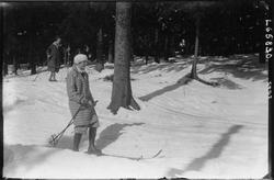 To kvinnelige skiløpere på ski i skogen.