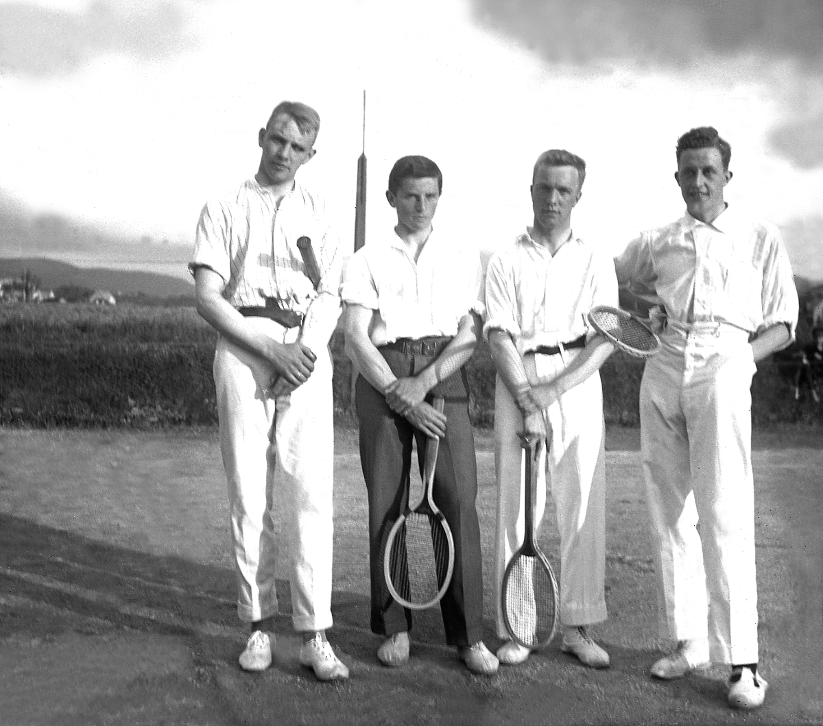 Fire unge menn, Fritjof Arentz nummer to fra venstre, på tennisbane, antagelig i Trondheim. Fotografert 1920.