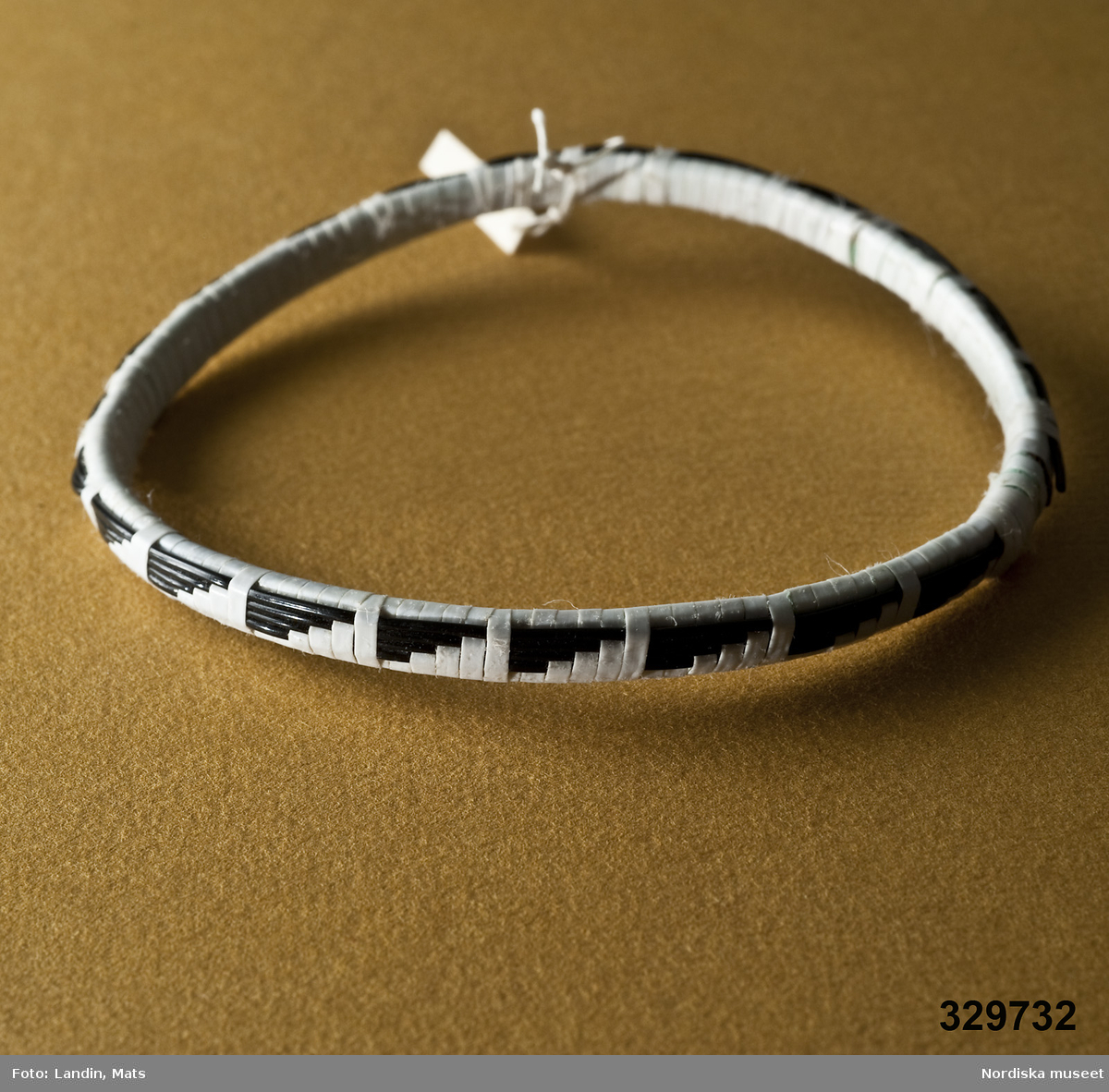 Runt armband vävt av smala plastband med mönster i svart och vitt. Afrikanska eller sydamerikanska influenser.
/Zingoalla Rosenqvist 2009-02-05