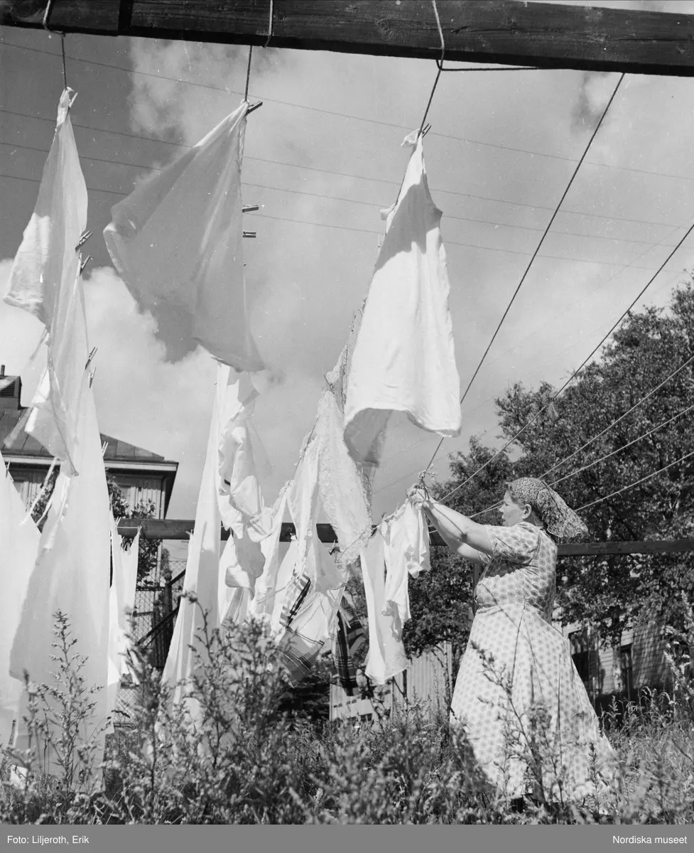 Göteborg. Kvinna hänger upp tvätt utomhus.