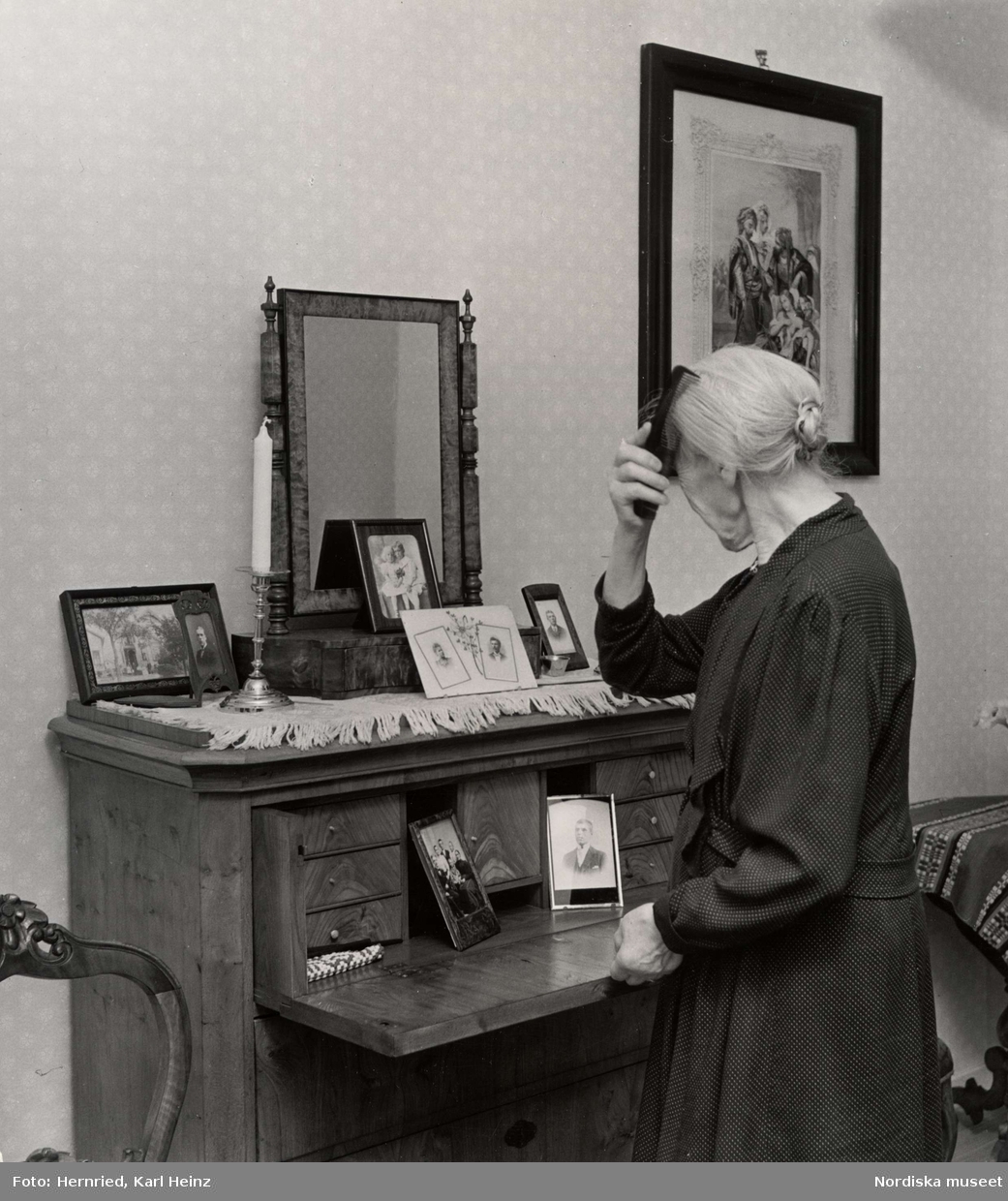 Sundbybergs ålderdomshem, Uppland. Kvinna kammar sitt hår framför spegel i pigtittare