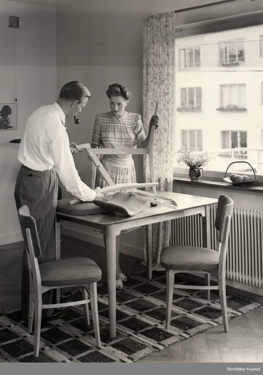 Interiör från kök där man och kvinna monterar ihop köksmöbler ur NK:s, Nordiska kompaniet, TRIVA-serie.