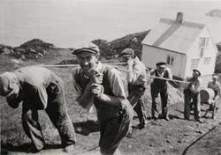 1949. Arbeidslag trekker opp oljetank på Geitungen fyr.