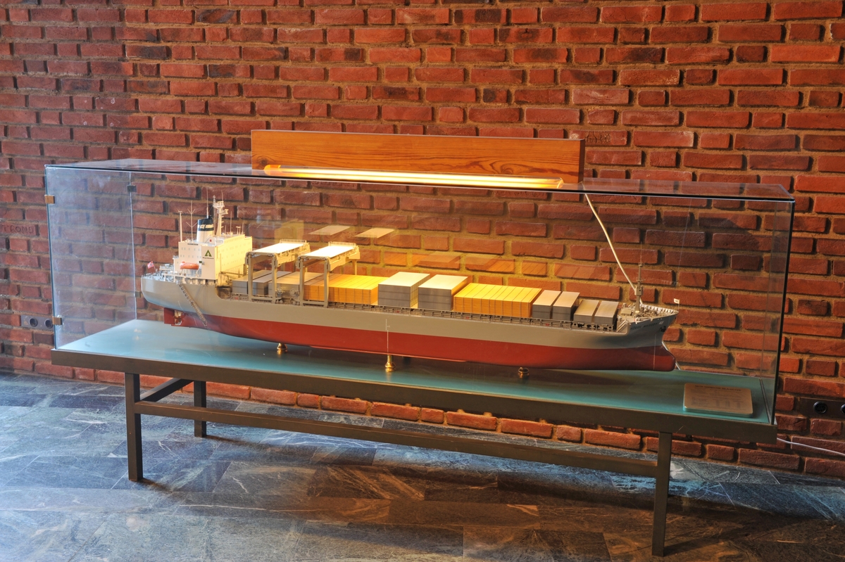 Skala  1:100 . Hvitt overbygg med firmalogo Weyerhaeuser på sidene, blå skorstein med hvitt flagg med blå H, grått fribord, brunrødt undervannsskrog. Open hatch-skip som også tar  containere og tømmer .