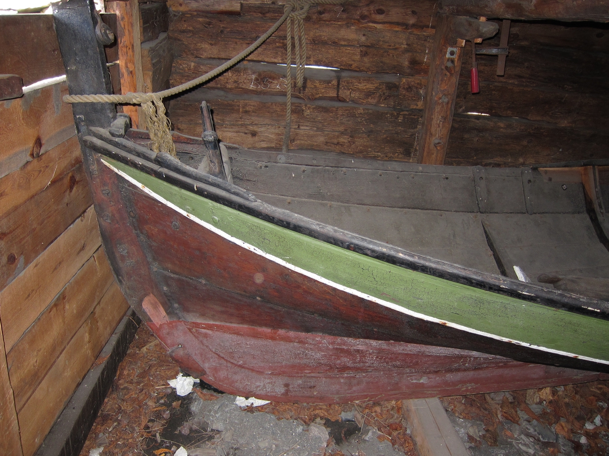 Åpen Nordlandsbåt med plass til tre roere på hver side. Aktre keip st.b.side skadet. Reparasjon st.b. side v. fremre keipe.