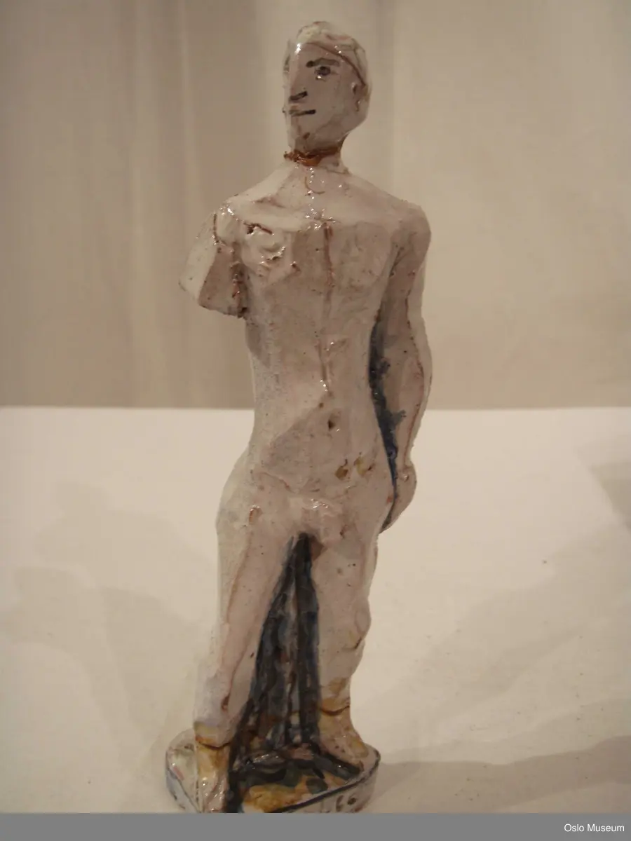 Scenografimodell av keramikk. Glasert i hvit bunnfarge med dekor/detaljer i blått og gult. 7 deler. Spesiallaget oppbevaringseske.