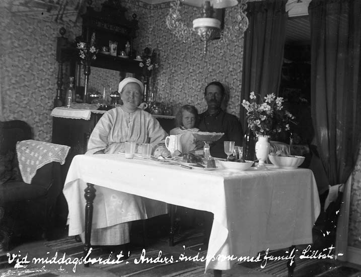 Enligt text skriven på glasplåten: "Vid middagsbordet! Anders Andersson med familj. Lillsäter. 19 juni 1923".
