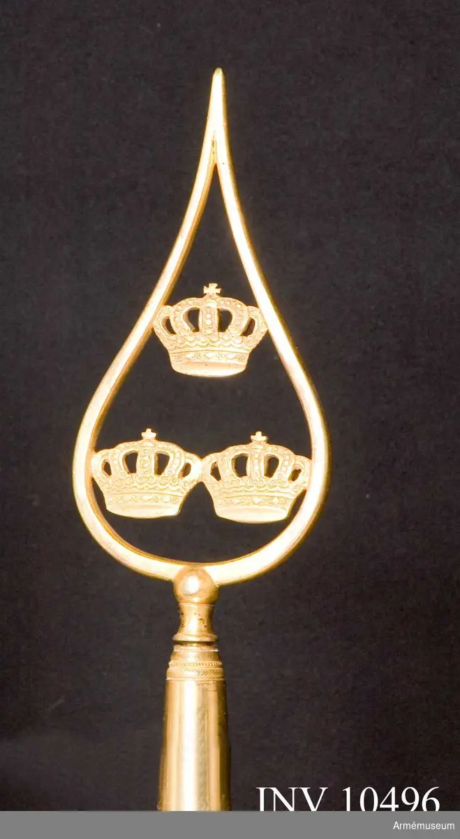 Grupp B.
Duk av taft, dubbel, delad i två halvor, den övre gul, den undre blå. Broderade emblem. På ena (inre) sidan Carl XV:s namnchiffer, dubbla C omkring XV, under sluten kunglig krona. Allt i guld, kronan dessutom med foder i rött silke, pärlor i silver och stenar i blått och rött silke, plattsöm. På andra  yttre sidan Skånes sköldemärke, ett rött griphuvud med öppen krona. Huvudet är vänt från stången och broderat i olika röda silken i schattersöm, med svarta konturer och vitt öga. Kronan gul med pärlor i silver och stenar i rött silke, allt i plattsöm. Kantad med sidenband och 60 mm bred frans av silke i dukens färger. Fäst med tre rader förgyllda spikar på sidenband  i dukens färg. Bredd utan frans 550 mm, med 730 mm.Stång av furu, övre delen räfflad, nedre delen slät, målad blå, med gult i räfflorna. Längd från spetsen till dukens underkant 600 mm, till handgreppets överkant 1370 mm, till handgreppets nederkant 1580 mm och totalt 2690. Löpande bärring på 220 mm  lång stång av järn. Stigbygelholk med rem fäst vid bygeln, allt av tunnt läder.

Spets av förgylld mässing, bladet med tre kronor ställda en och två inom enkel lyrformig ram. Bladets längd 183 mm. Holkens längd 95 mm.Samhörande är ett fodral av brunt läder med ficka för spetsens blad och rund knapp med skvadronsmärke. Längd 750 mm.
