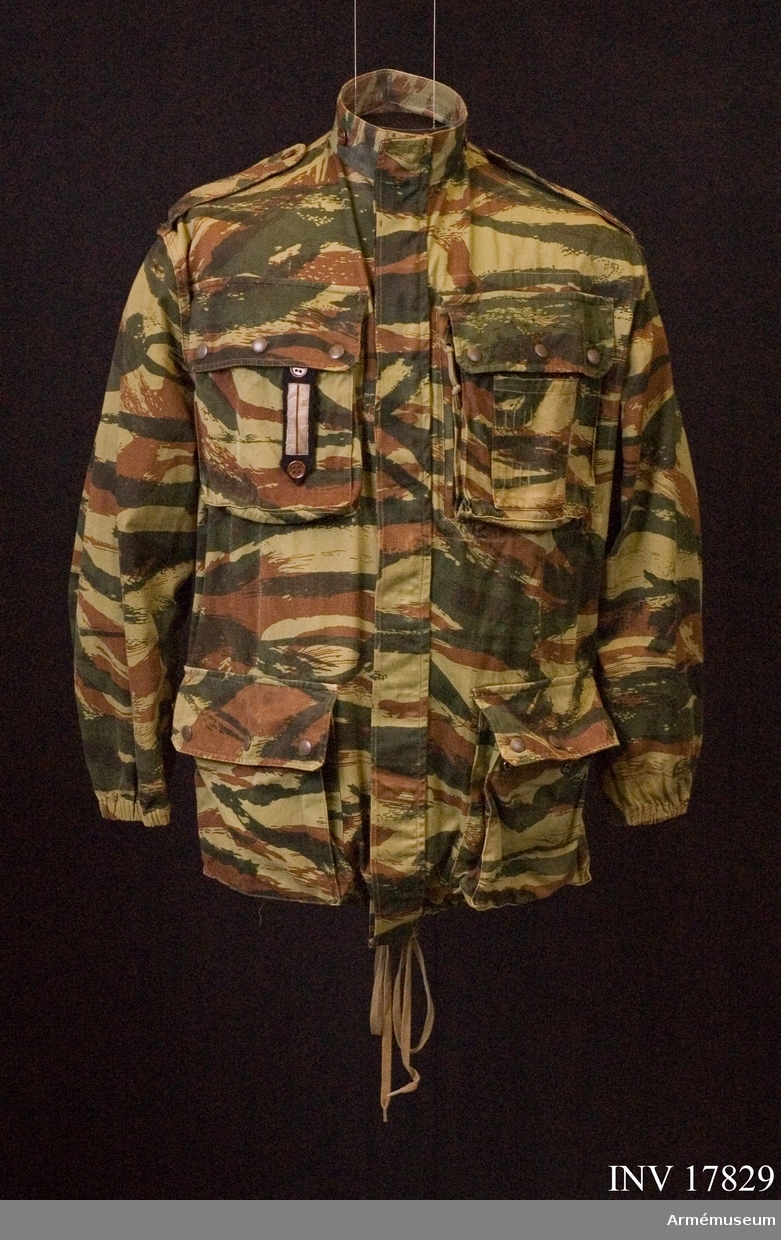Grupp C I.
Jacka "Veste camouflage".
Ur uniform för löjtnant vid 1 ére regiment de Hussards parachutiste Algériet, 1959-1960, Frankrike.
Uniformen består av jacka, byxor, basker, livrem, kängor, pistolhölster och fältflaska med överdrag.
