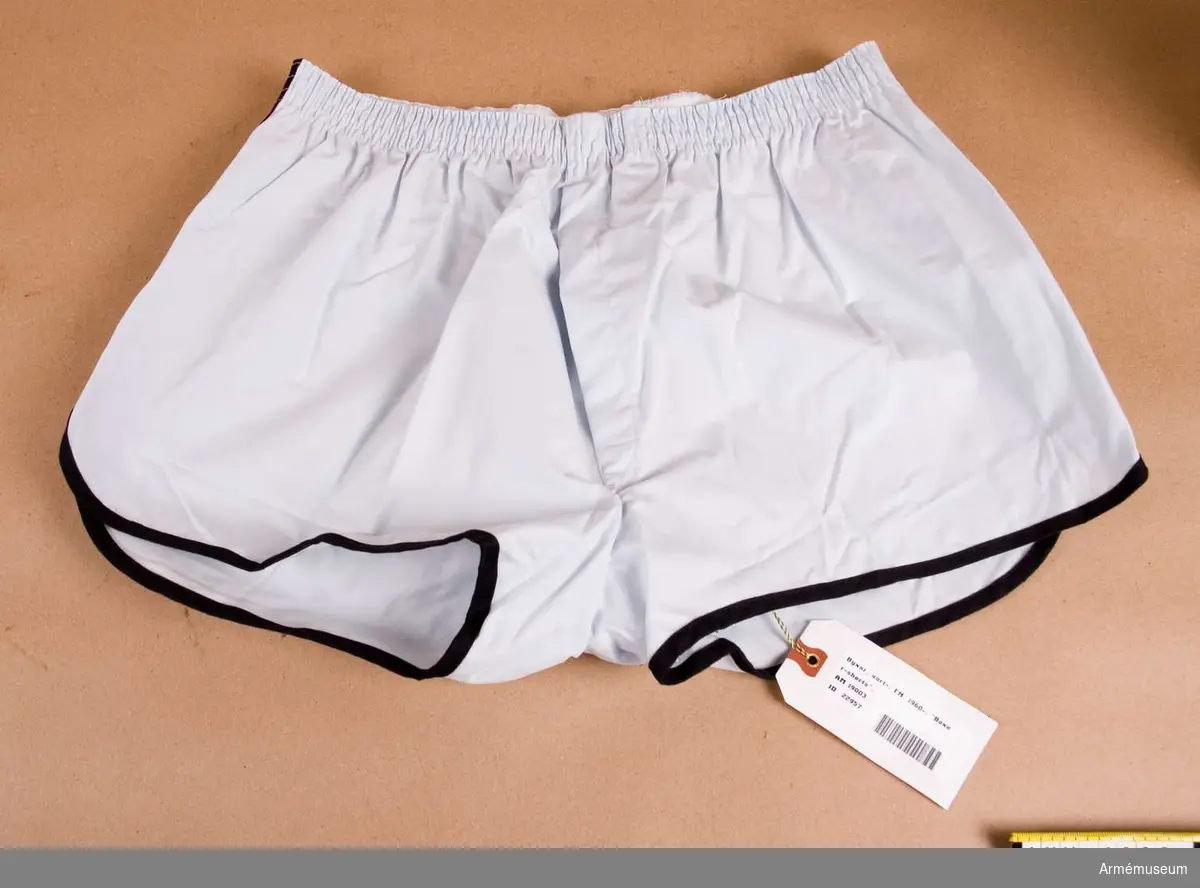 Boxer-shorts, FN-tjänst. Av ljusblå bomullspoplin med svart kantlist.I midjan resår Storlek 5.
Tillverkare Vinson. Etikett med text:Vinson  kläder för karlar 5.