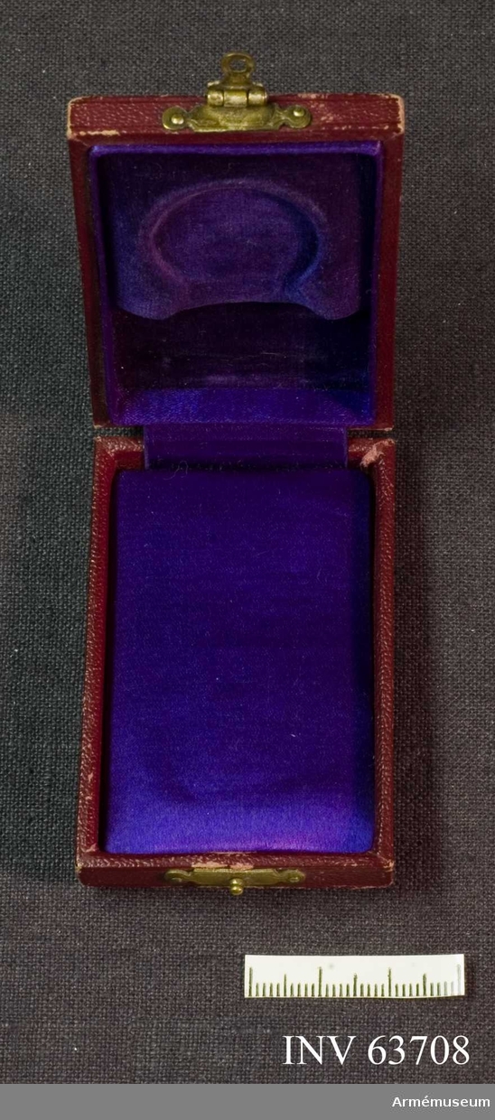 Grupp M II.
Medaljask, vinrött etui av skinn? Invändigt klädd med lila sammte och i locket violett satin.