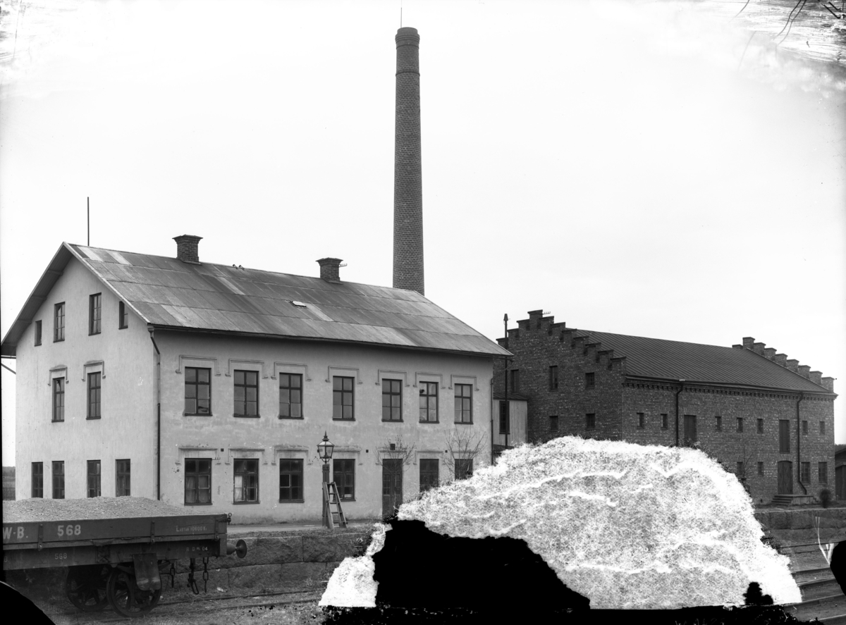 "Brödfabriken och sädesmagasinet, 1906". Banområdet vid Enköpings järnvägsstation, vy från sydväst. Troligen de byggnader som hästbrödsfabriken BendOr hade verksamhet i 1897-1906.