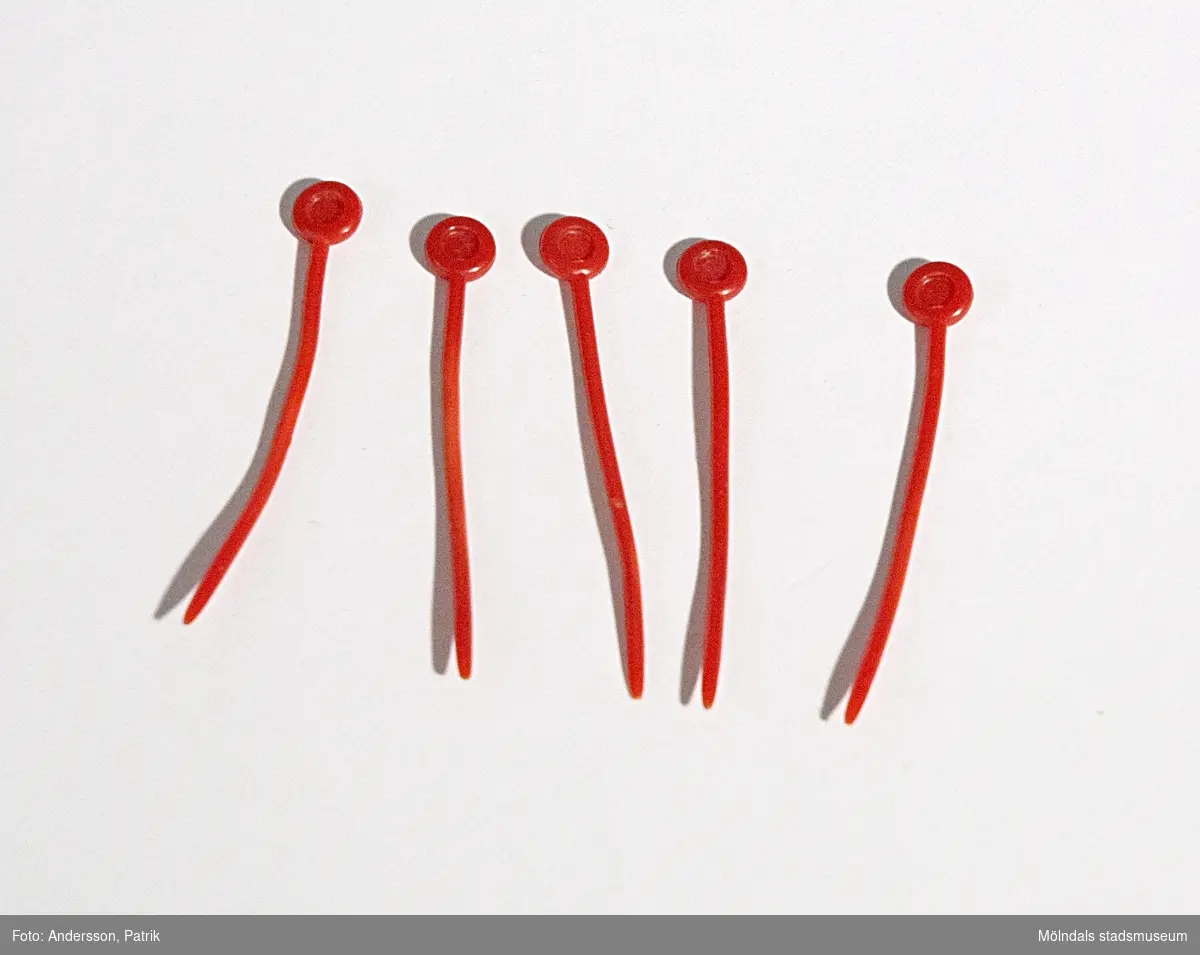 5 st röda pinnar tillhörande papiljotter (MM04838-04839).Givaren Kerstin Olofsson använde sig av dessa för att locka sitt hår under 1970-talet.  De är mycket använda.MåttLängd: 60 mm