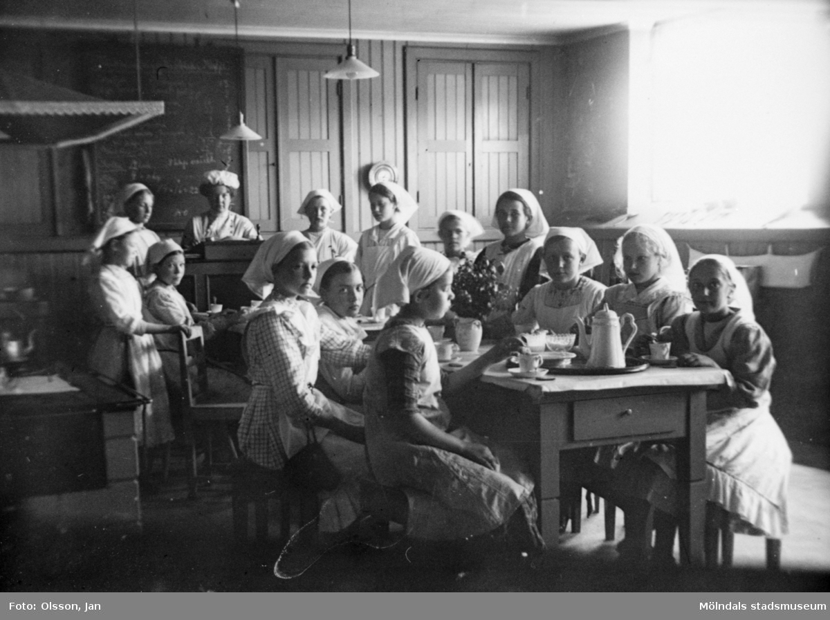Läraren Hilda Olsson med elever i Trädgårdsskolans skolkök, år 1910. Trädgårdsskolan (senare kallad Träskolan, revs 1986) låg där Kvarnbyskolan har sin skolgård.