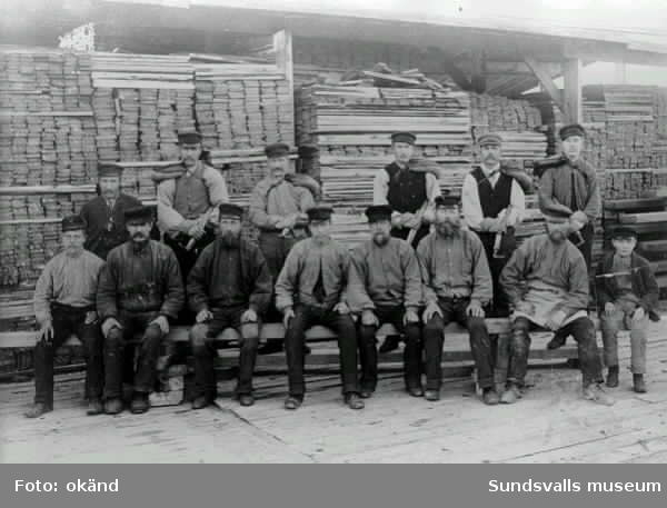 Gruppbild med sågverksarbetare på Nyviks sågverk. Nr 3 fr v, sittande, är Isak Billström, som var med och bildade Nyviks musikförening och själv spelade fiol.