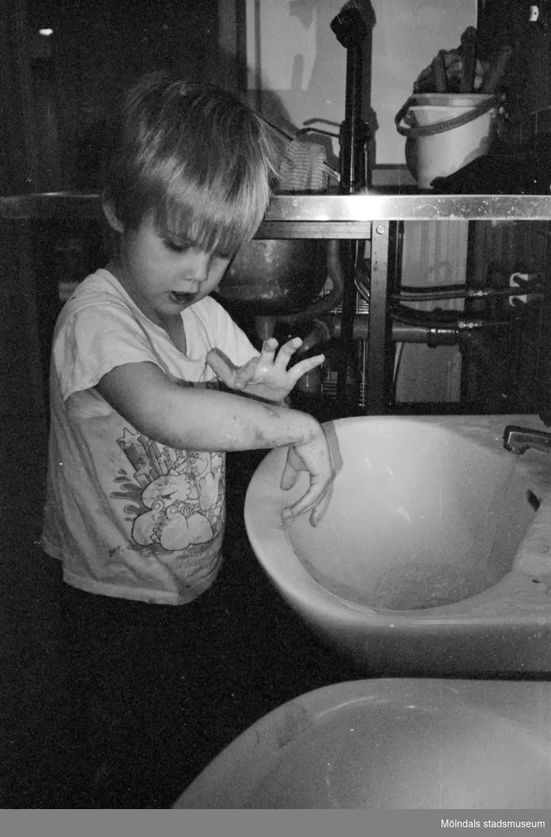 Ett dagisbarn tvättar händerna vid ett litet handfat för barn. Katrinebergs daghem, 1992-93.