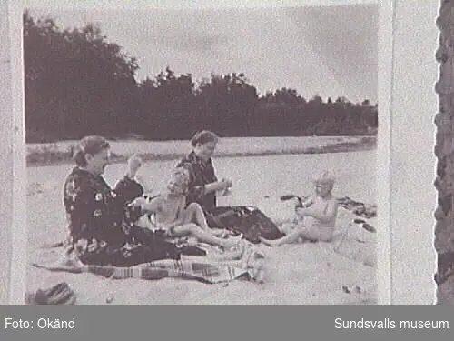 Kvinnor och barn på stranden.