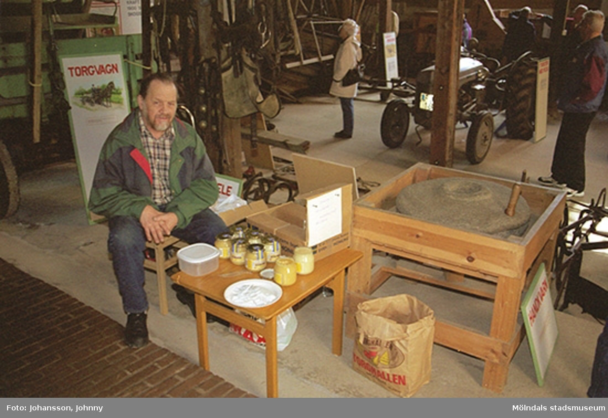 En man säljer honung inne i Lantbruksmuseets lokaler på Götaforsliden 14A.