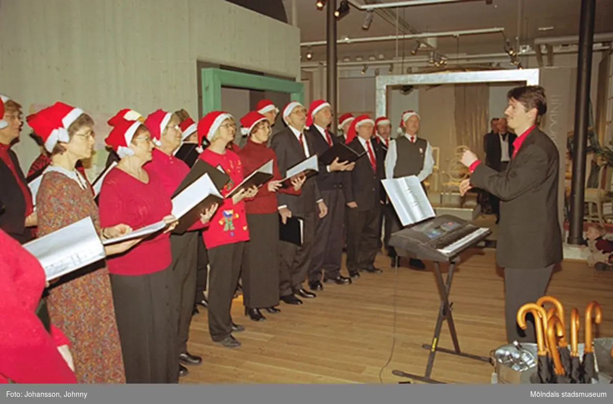 Opus sångkör sjunger på Mölndals museum 2002-12-15.
Tomteutställningen: 30/11-02 - 1/1-03.