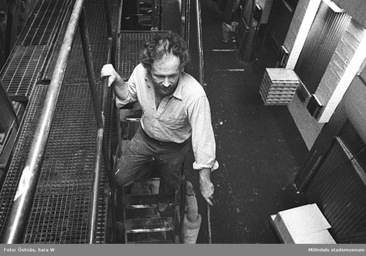 Juris Kuvalds på väg nedför en trappa i Byggnad 6, 1980-tal. 
Bilden ingår i serie från produktion och interiör på pappersindustrin Papyrus.