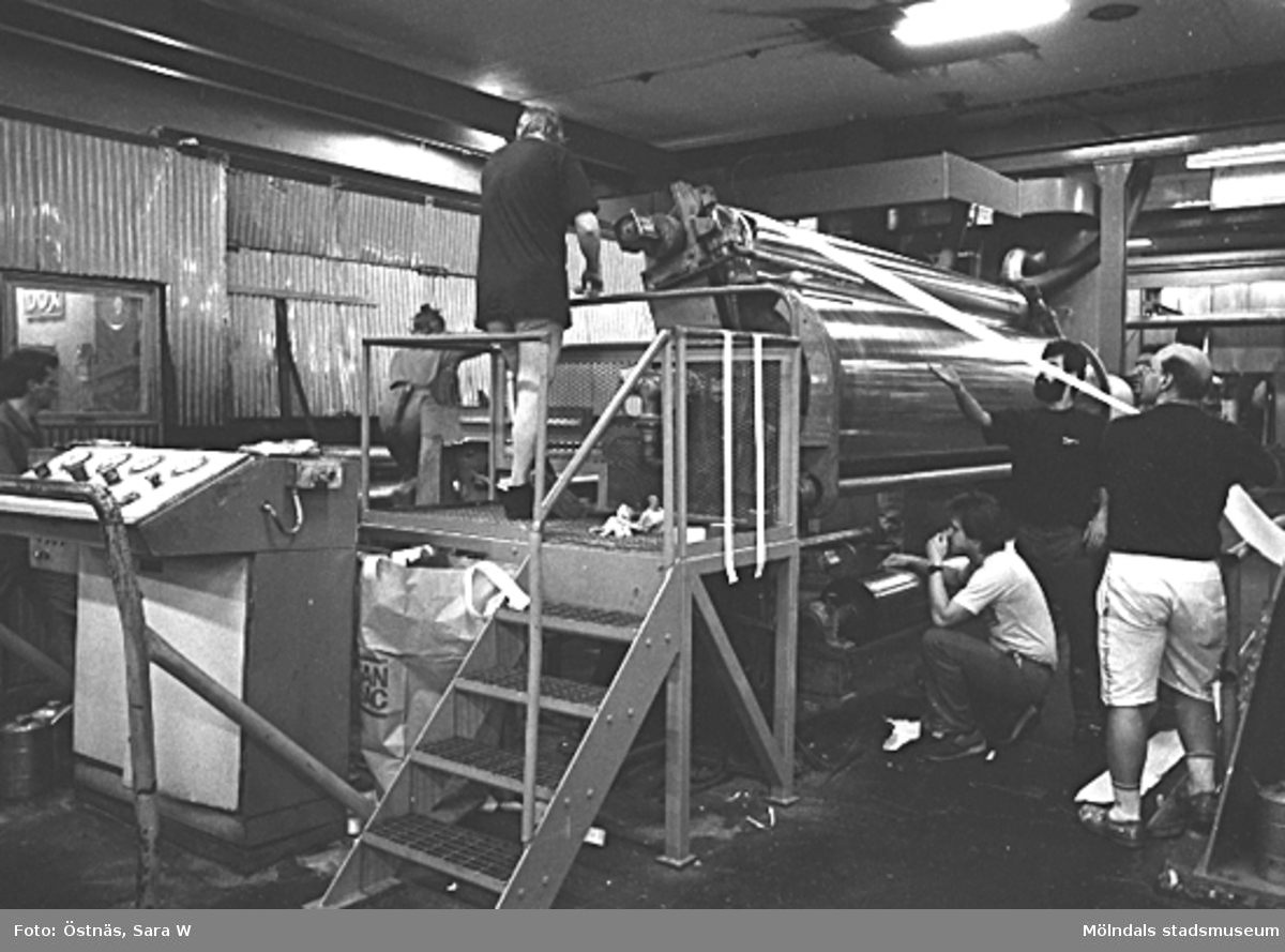 Män i arbete med spetsdragning i Byggnad 6, KM 2, 1980-tal. Mannen till vänster är Anders Severed och mannen i skägg är Kawa Mohideen. 
Bilden ingår i serie från produktion och interiör på pappersindustrin Papyrus.