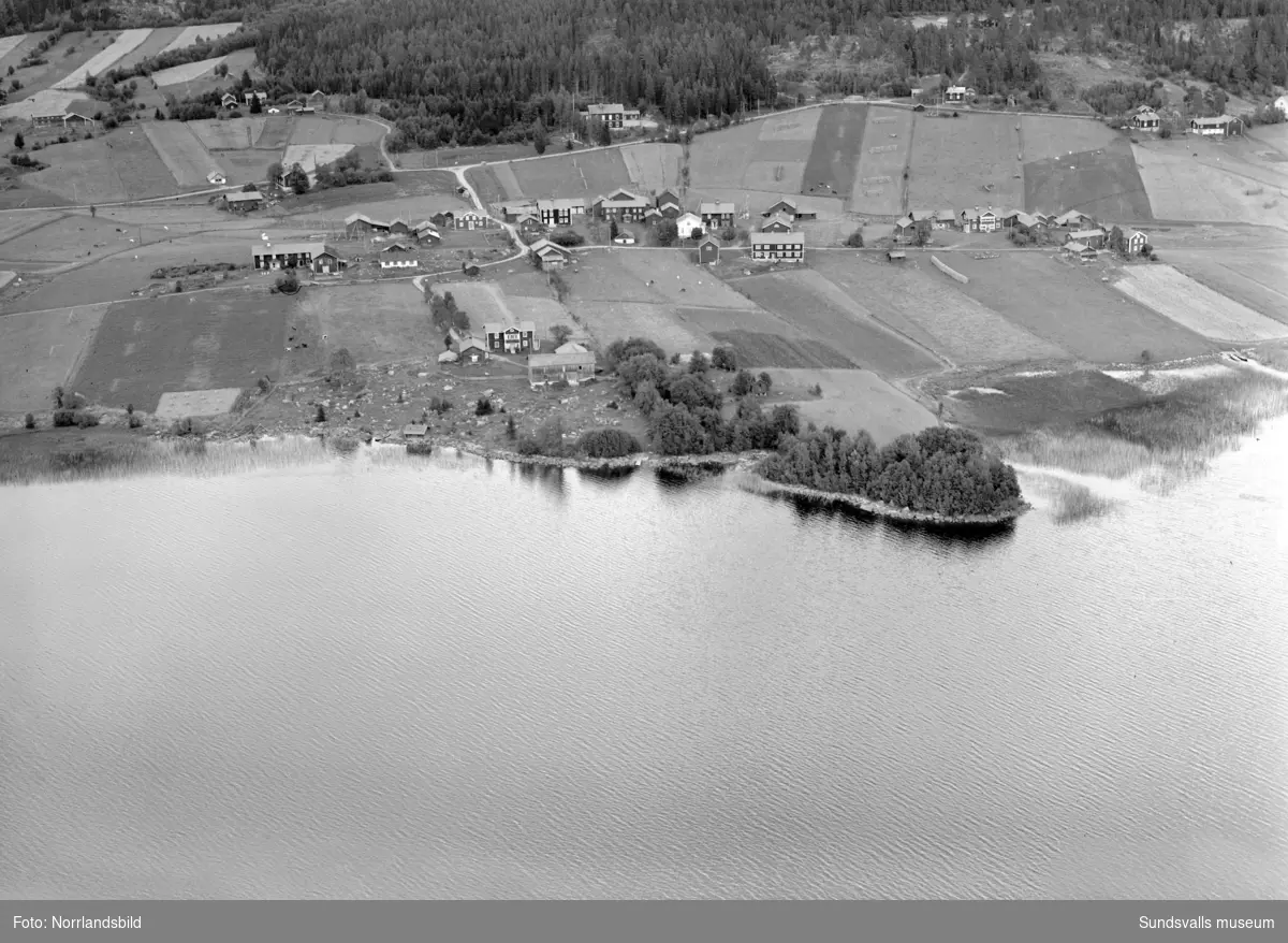 Flygfoton över Harvs by vid sjön Vikarn i Attmar, före den stora branden. I överkant syns Harvs gamla skola.