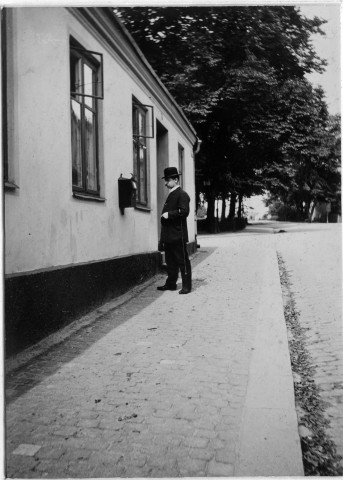 Album med fotografier från postkontoret i Ystad och porträtt av
posttjänstemän därstädes. Gåva till postmästare K. E. Paulson i Ystad
1912. Brevlådan å St. Nonegatan Ystad