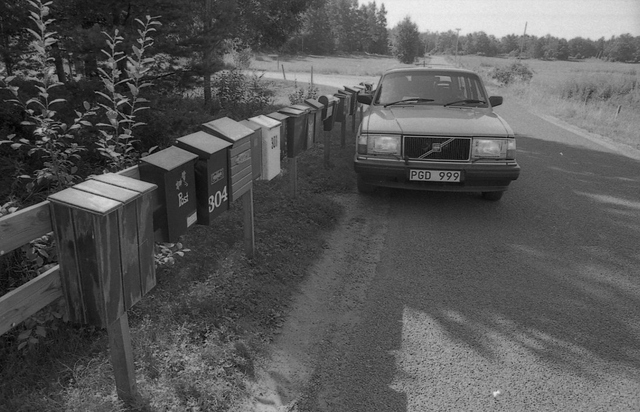 Lantbrevbärare Reinhold Andersson delar ut post till postlådor från
sin postbil. Tillhör en dokumentation av en lantbrevbärare i trakten
av Valdermarsvik av fotograf Ove Kaneberg.