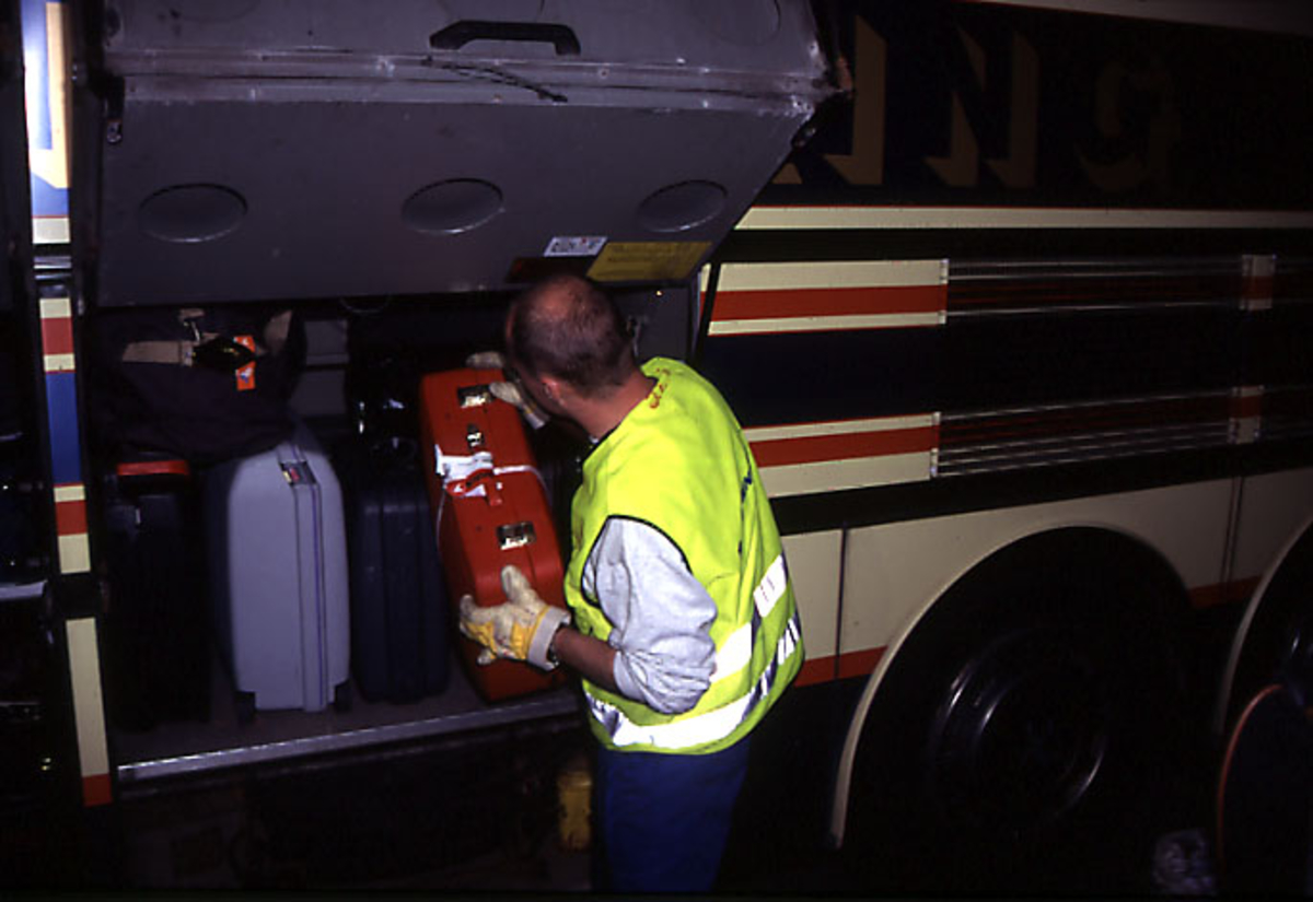 Lufthavn, portrett, 1 person, bakkepersonell, laster bagasje inn i en buss.