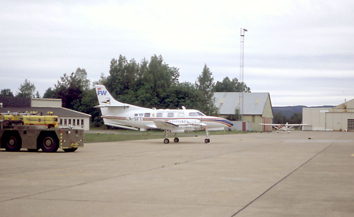 Lufthavn, to fly på bakken. I forgrunnen Fairchild Aircraft Corporation SA226-T(B) FW LN-SFT fra Kystvakten. 