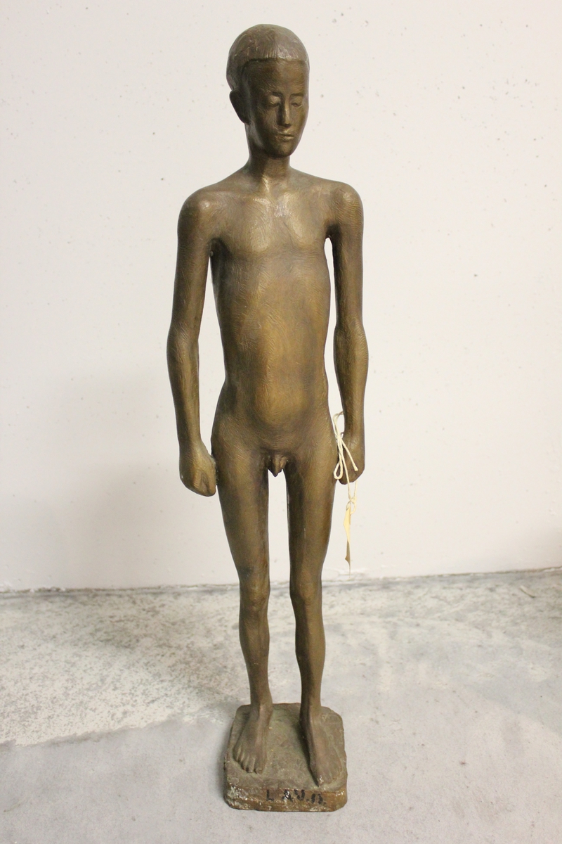 Skulptur i bronse av en ung gutt uten klær.