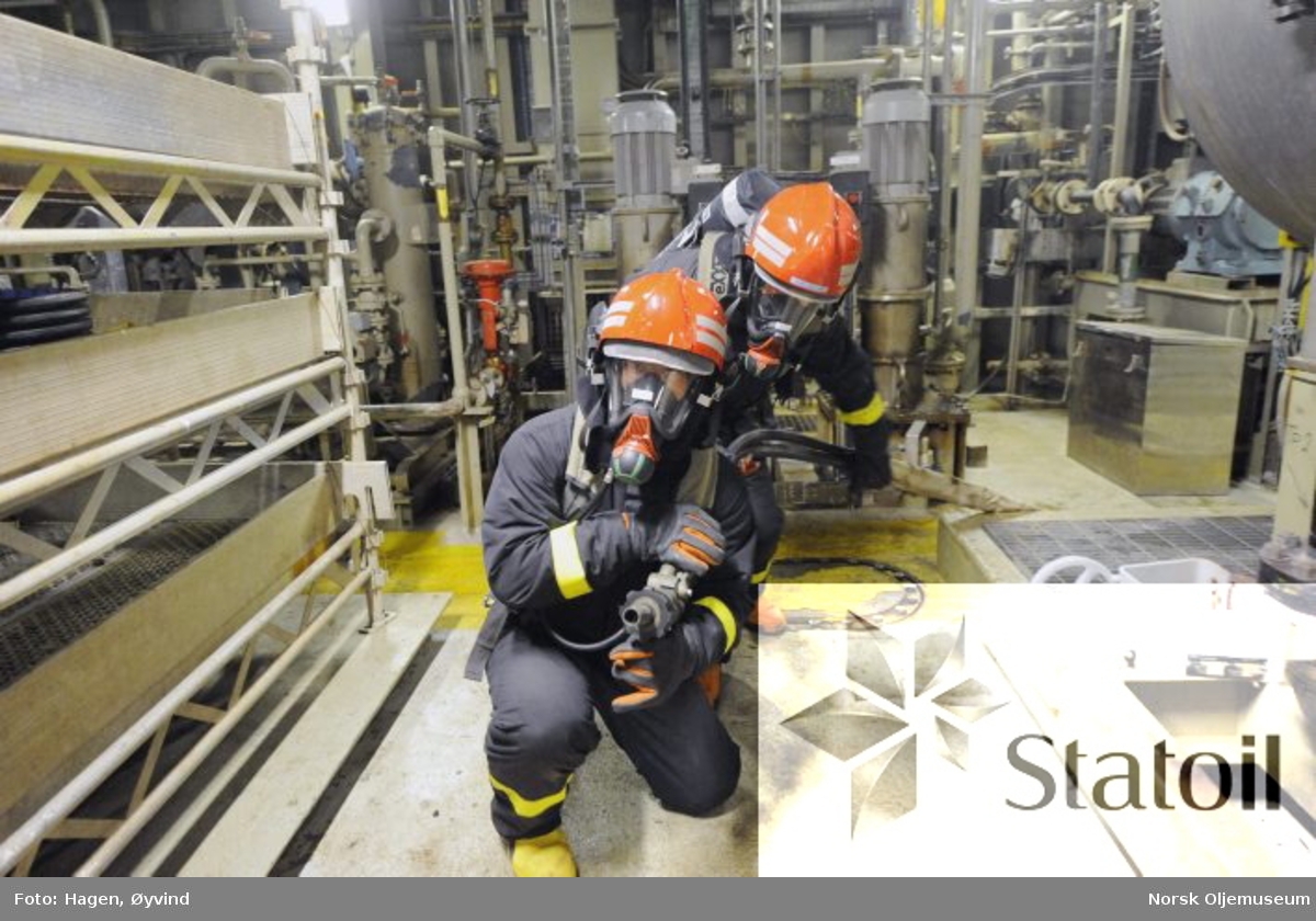 Beredskapsøvelse på Statfjord C.  To personer utstyrt med pusteluft  og verneutstyr er klar med brannslange.