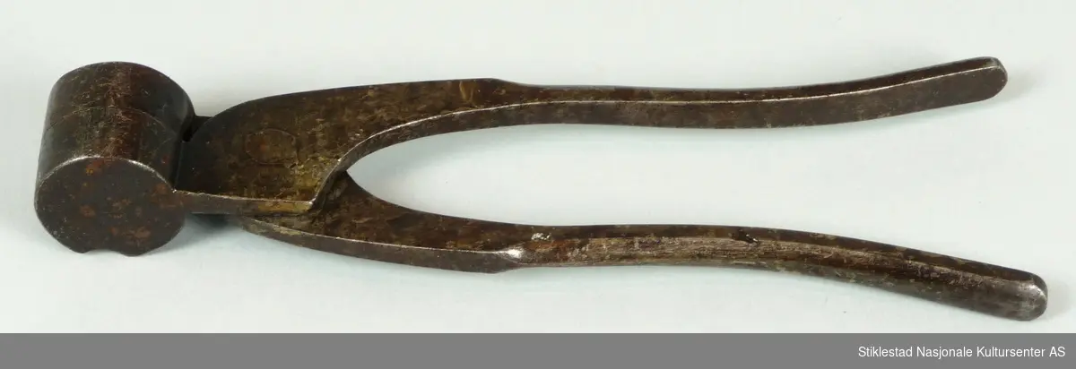 Tang i jern med hode/kjeft som danner støpeformen. Tangen ble brukt til støping av blykuler for  flintlåsbørse.