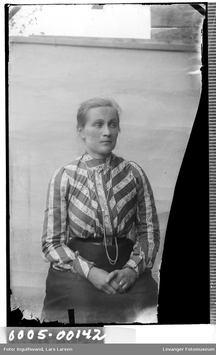 Portrett av kvinne i iført bluse og med klokkekjede.