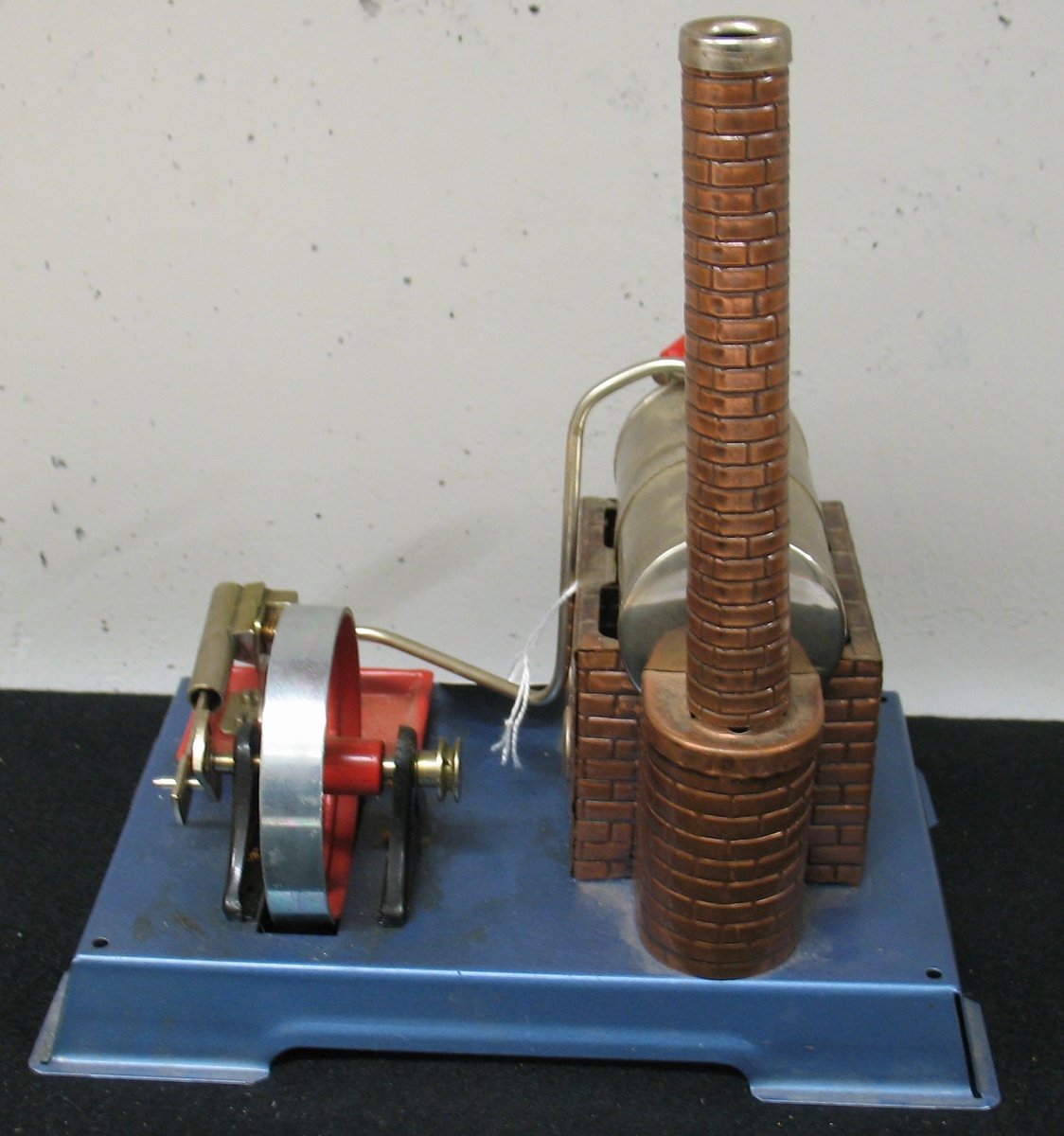 En av fyra  ångmaskiner, samtliga tillverkade på 1960-70-talen i Väst-Tyskland och tre med firmanamnet Wilesco. En av maskinerna förvaras ouppackad i originalkartong. Den minsta av maskinerna har avslagen skorsten och bucklad tank. Mått: L. 34,5 - 21,5 cm.  H. 31 - 21 cm.  B. 29 - 13,5 cm.Å