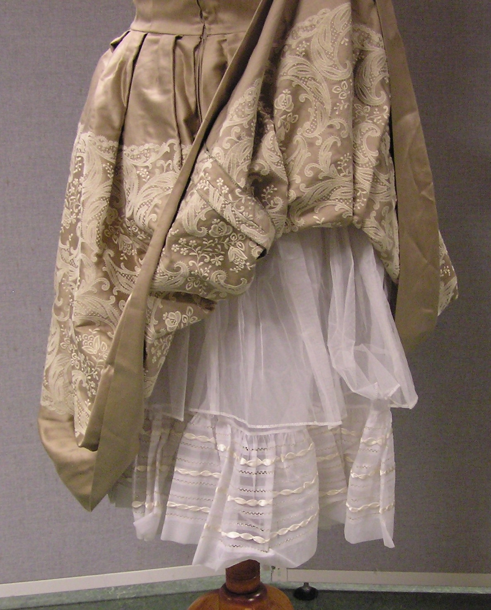 Felt med blomster ( paisley motiver ) midt på skjørtet.