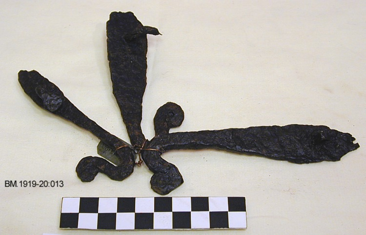 Tre sledekroker av jern, som Jan Petersen: Vikingetiden redskaper, fig.49, med flatt endestykke og en nagle. Enden av kroken opprullet til en spiral. Lengde 10,5 cm, 11 cm og 12,5 cm, bredde henholdsvis 2,5 cm, 1,6 cm og 2,5 cm.

