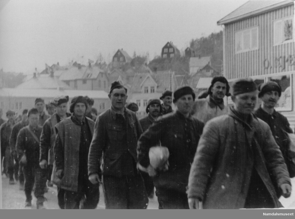 Namsos. Russernes siste dag i fangenskap med tyske soldater i marsj. Russerne har fått pakker (antakelig ved Snippen 7. mai 1945).
