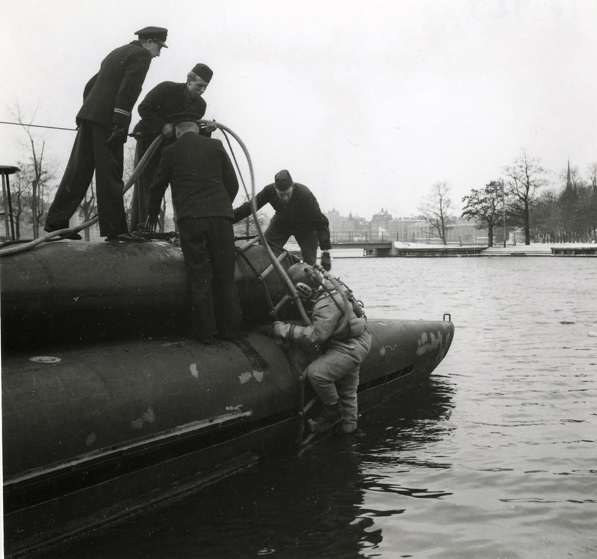 Dykarbete på ubåten Sjöormen vid Skeppsholmen 1949.
Tungdykare går ned vid ubåten.