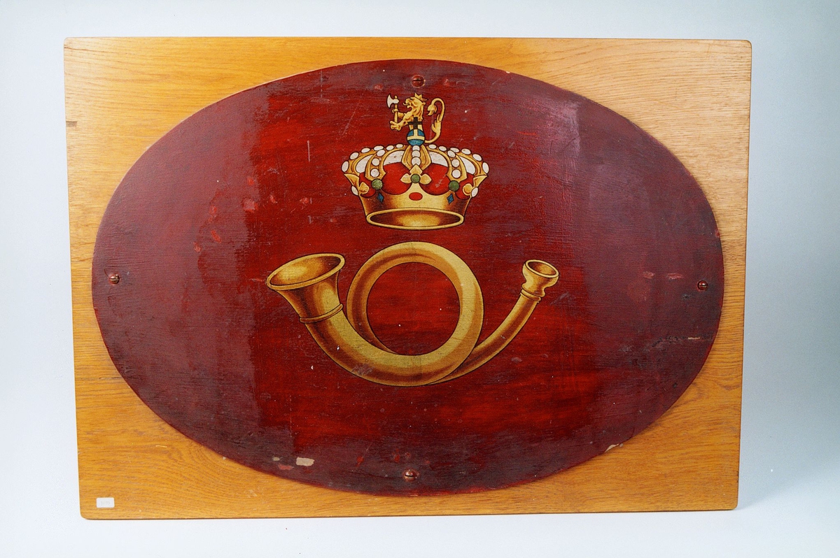 Postmuseet, gjenstander, skilt, ovalt postskilt, posthorn og krone med riksløve (postlogo) malt på en plate, kronen har svensk flaggfarge under løven.