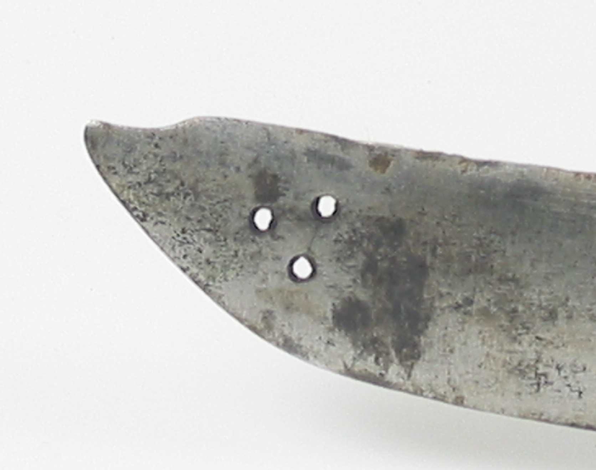 Pyramideformet knapp med strekdekor. Asymmetrisk kurvfeste med to sidebøyler( øverste avbrukket )med riflede fortykkelser på midten. mellom håndbøylen og kurvens ytterkant. Innsiden har en  sidebøyle. Kurvens basis er på utsiden en kvadratisk parérplate med to hjerteformede gjennombrytninger. På innsiden er det en klingebrekker og tommelbøyle. Opp og nedbøyde parérstenger med riflede fortykkelser på endene.
Tregrep med nyere jerntrådvikling.
Enegget krum klinge med 3 hull ipå klingspissen og en smal hulslipning på ryggsiden.Tre smedmerker på venstre side. 