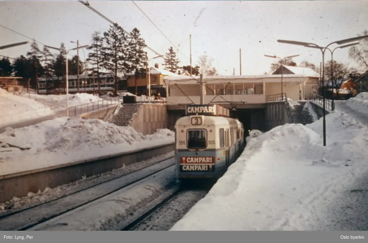Høkatrikk, linje 3 til Bøler, med Campari reklame i forgrunnen. Her ved Oppsal stasjon.