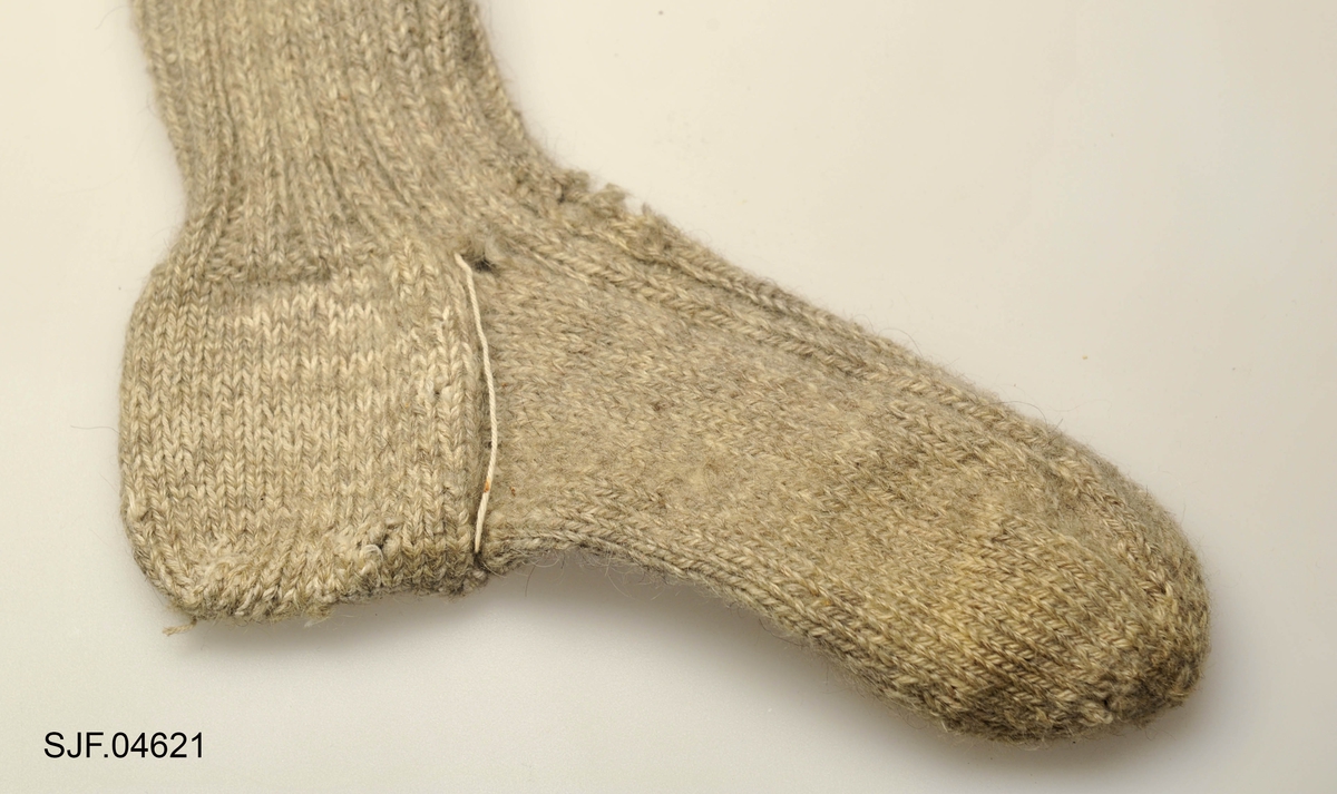 To gråfarger. Ribbestrikket oppå foten og nederste halvdel av leggen, 
Brukt av giverens onkel, Ingvar Galåsen (1880-1969)
