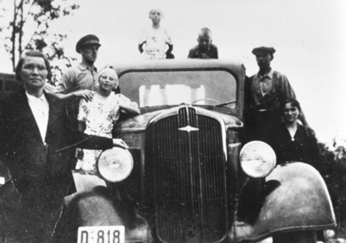 Martin Johansen og broren Alf kjøpte sin første bil i 1934, en gammel Ford som de eide sammen. I 1936 kjøpte de en ny Dodge som de kjørte melkeruta med. Her familien samlet rundt bilen, D-818. Fra venstre er Karen F.1897, Alf F.1910, Jenny og Reidun Flikkenhaug, Johan Martinsen F.1931, Martin F.1904 med kona F.1904.