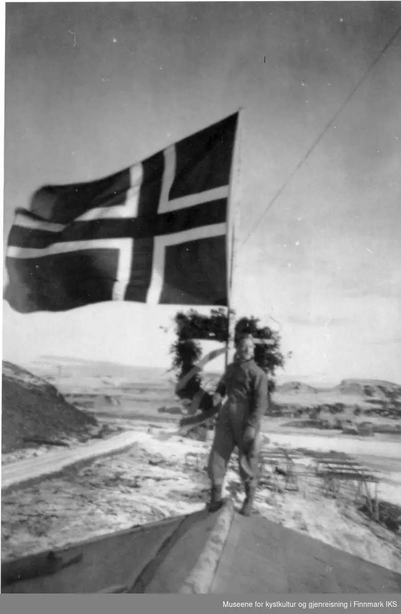 Ukjent mann på taket. Mønsåskrans og flagg da samfunnshuset i Kongsfjord var ferdig i 1959.